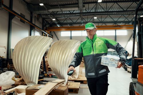 Mannlig Bring-bud leverer pakke hos en bedrift