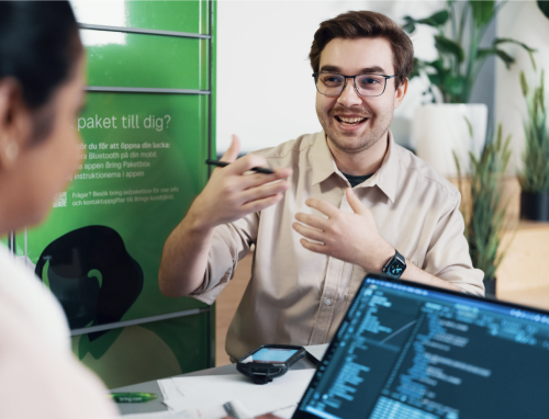 To ansatte i Posten Bring i hyggelig prat foran en pakkepoks fra Bring Sverige